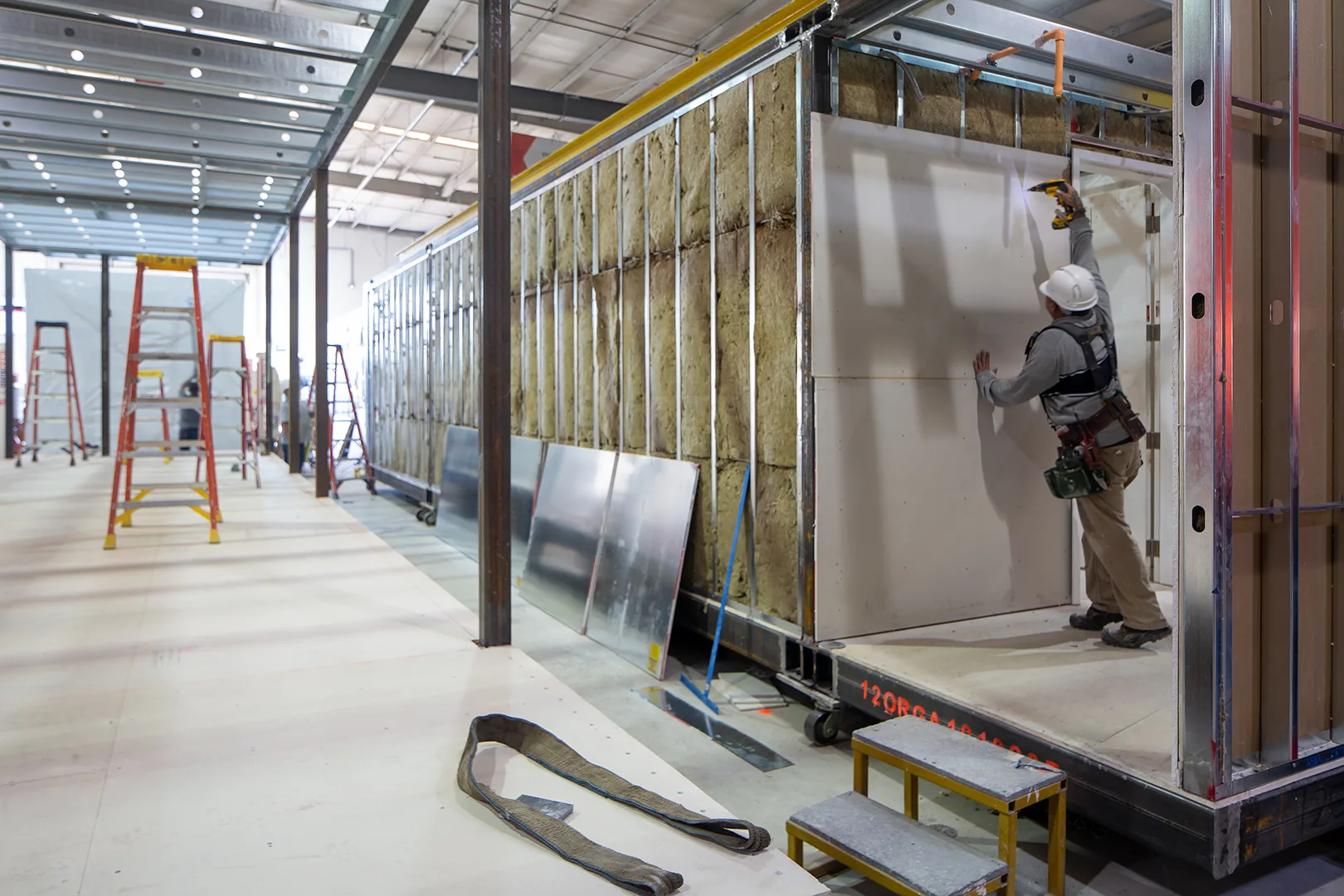 Module receiving insulation and drywall on the line
