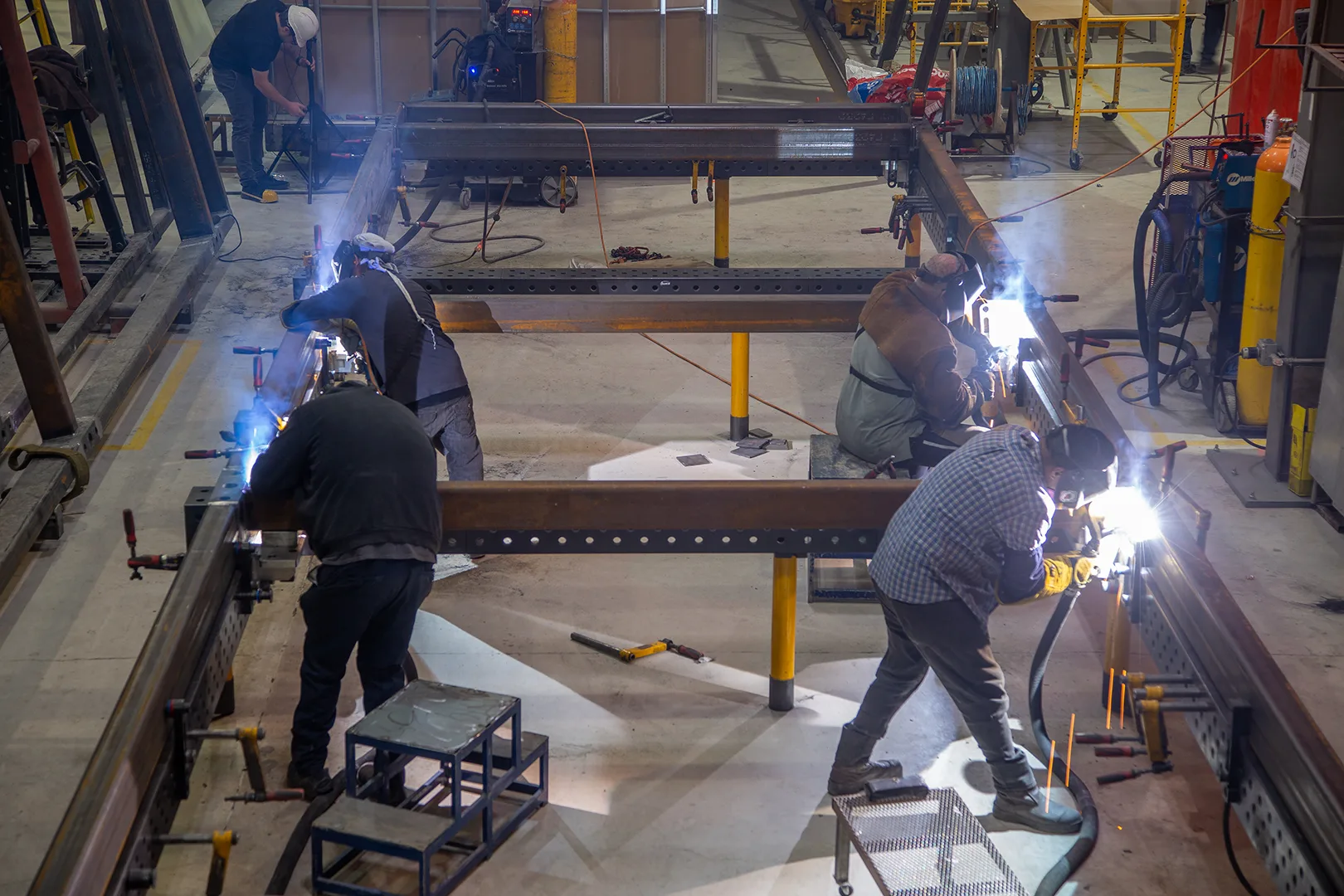 Welders assembling a steel module chassis